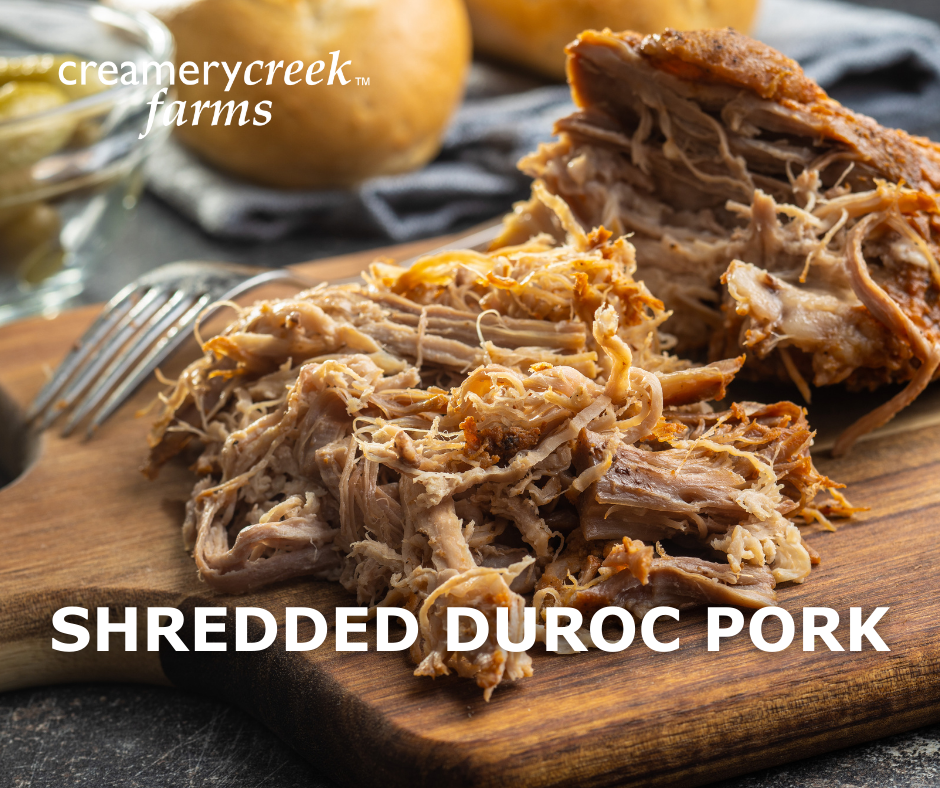 shredded pulled Duroc pork on a cutting board