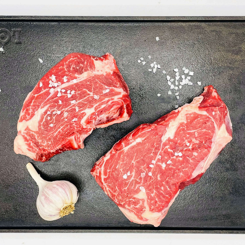 raw beef on a black plate with garlic