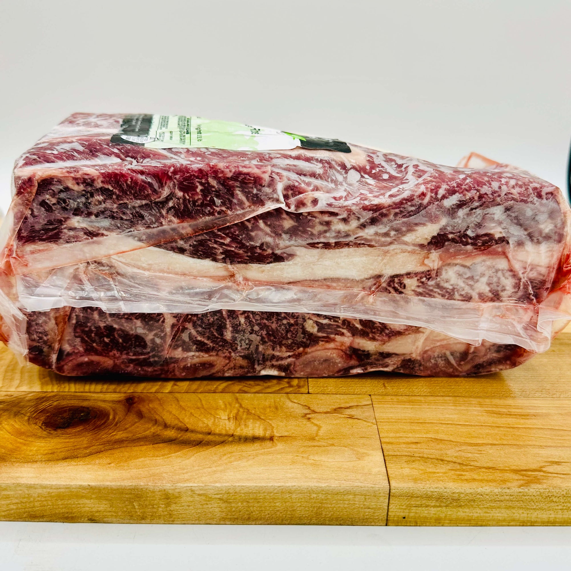 Side view Raw beef on a wooden cutting board with a white background