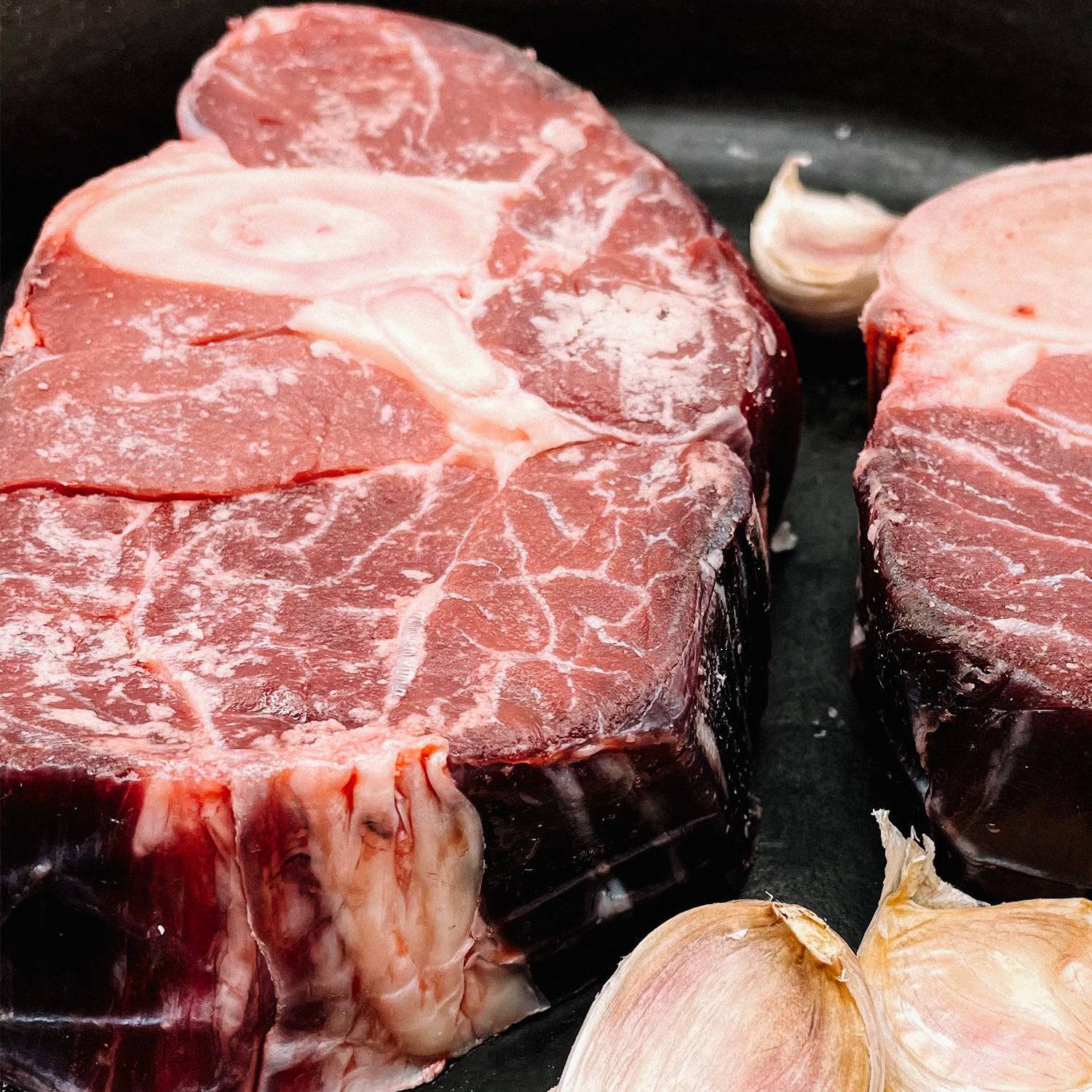 Close-up of Creamery Creek Farms Beef Shank Bones by garlic