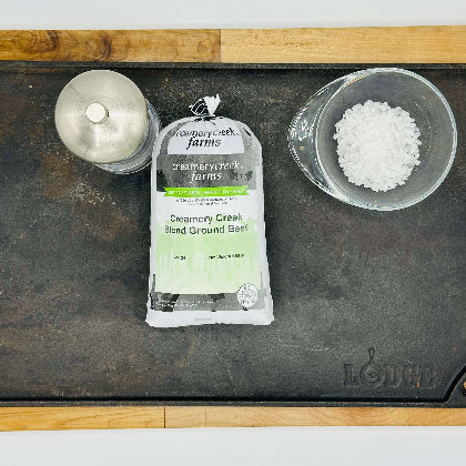 Creamery Creek Farms blend ground beef package on a Lodge grill pan with salt and pepper shakers.