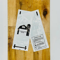 Two clear plastic packages with black text and graphics on a wooden surface