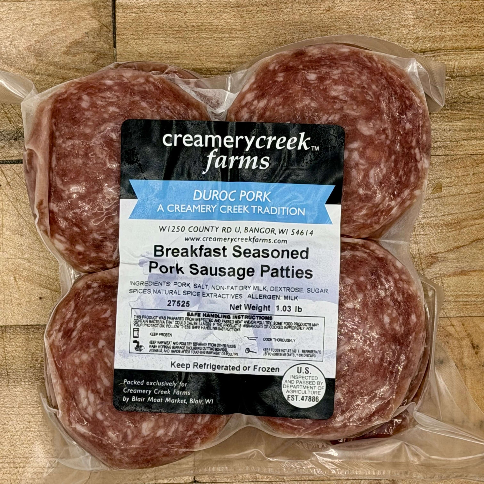 Packaged breakfast seasoned pork sausage patties with Creamery Creek Farms label on a wooden surface