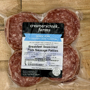 Packaged breakfast seasoned pork sausage patties with Creamery Creek Farms label on a wooden surface