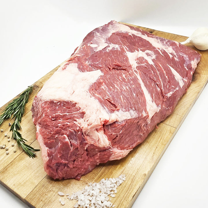 Raw meat on a wooden cutting board with rosemary and salt
