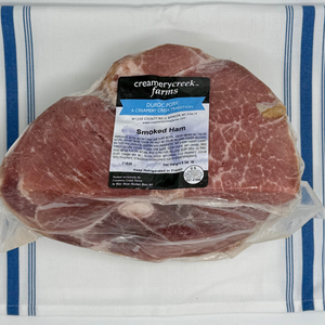 Packaged smoked ham with a label on a white and blue striped towel