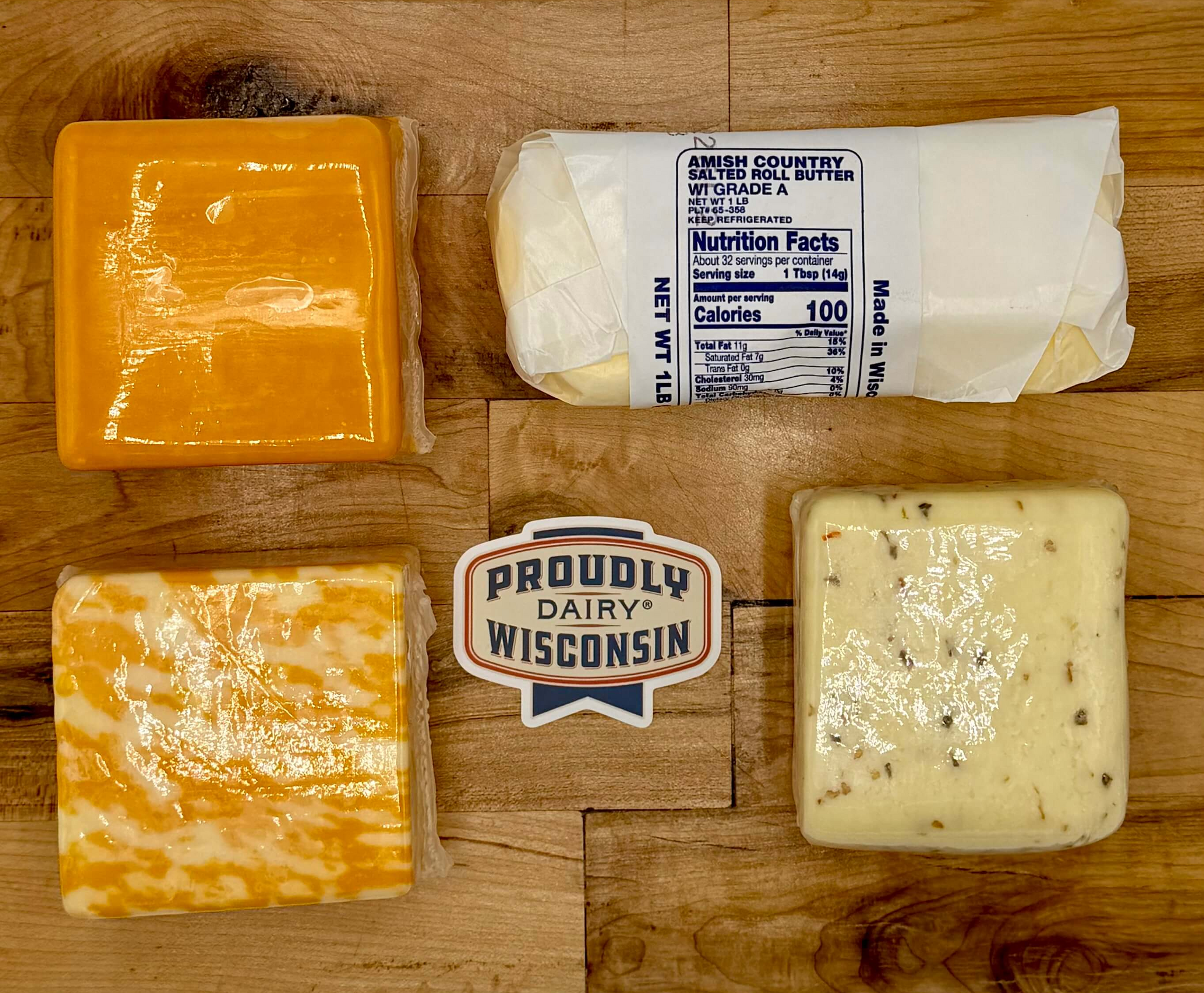 Assorted cheeses on a wooden board with a 'Proudly Dairy Wisconsin' label.