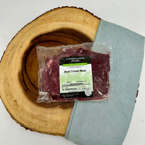 Packaged beef cheek meat with a label on a wooden surface