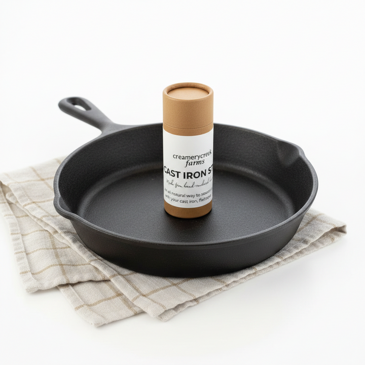 Black cast iron skillet with a canister of creamery &amp; cream brand product on a white background