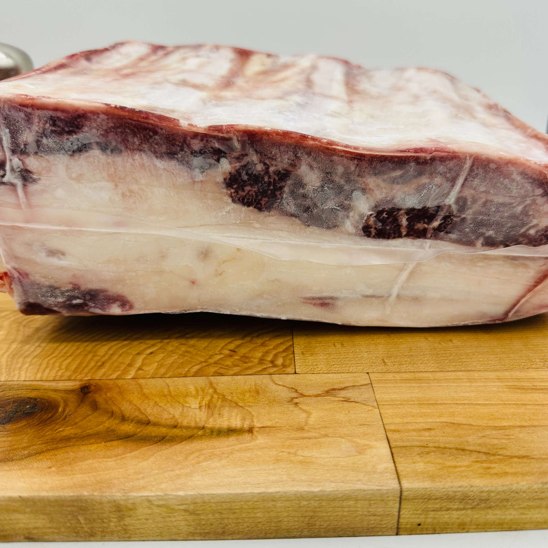 Raw meat on a wooden cutting board with a neutral background