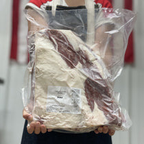 Person holding packaged dry aged brisket