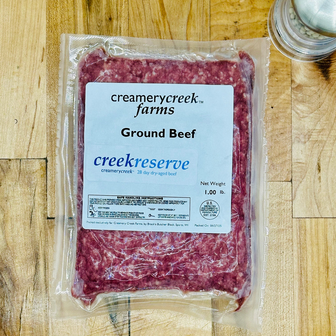 Packaged ground beef from Creamerycreek Farms on a wooden surface