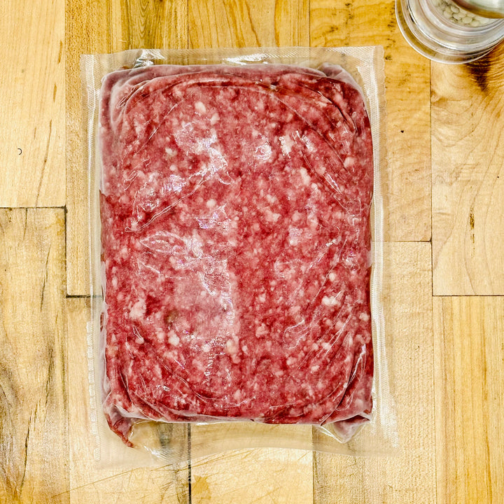 Packaged ground meat on a wooden surface