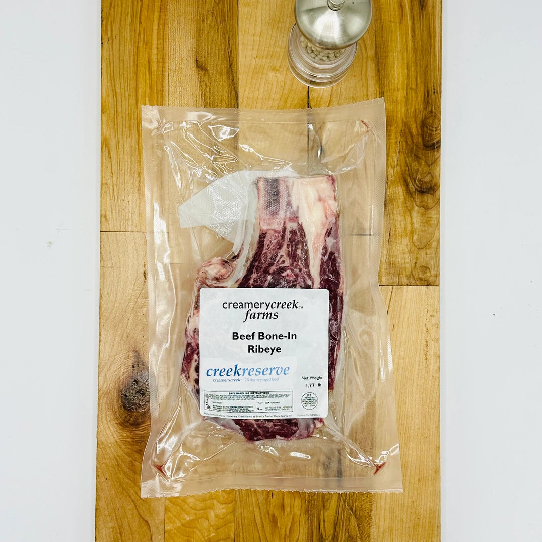 CreekReserve bone in ribeye steak on a cutting board