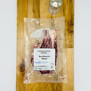 CreekReserve bone in ribeye steak on a cutting board