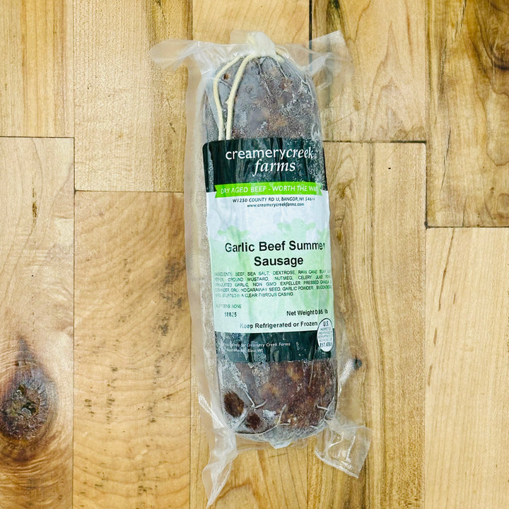 Packaged Garlic Beef Summer Sausage from Creamery Creek Farms on a wooden surface