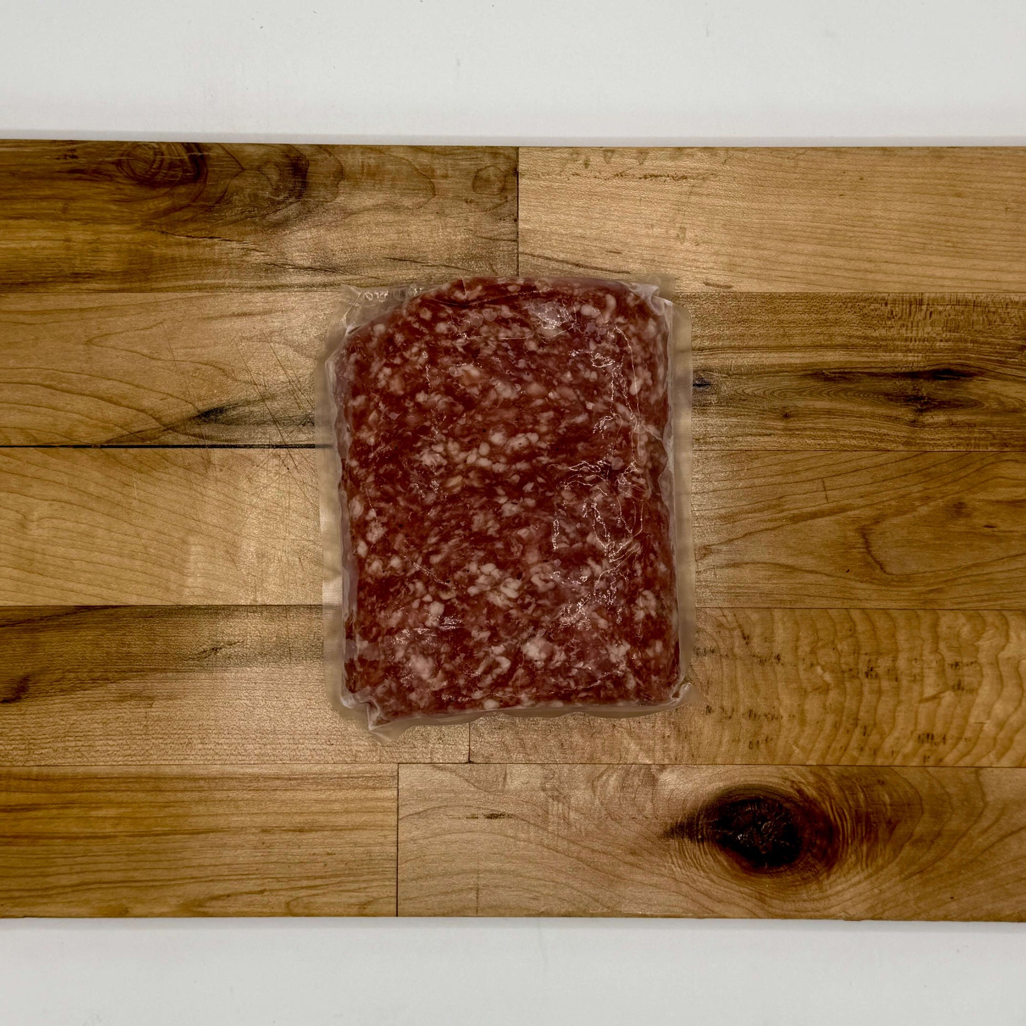 Packaged ground meat on a wooden surface