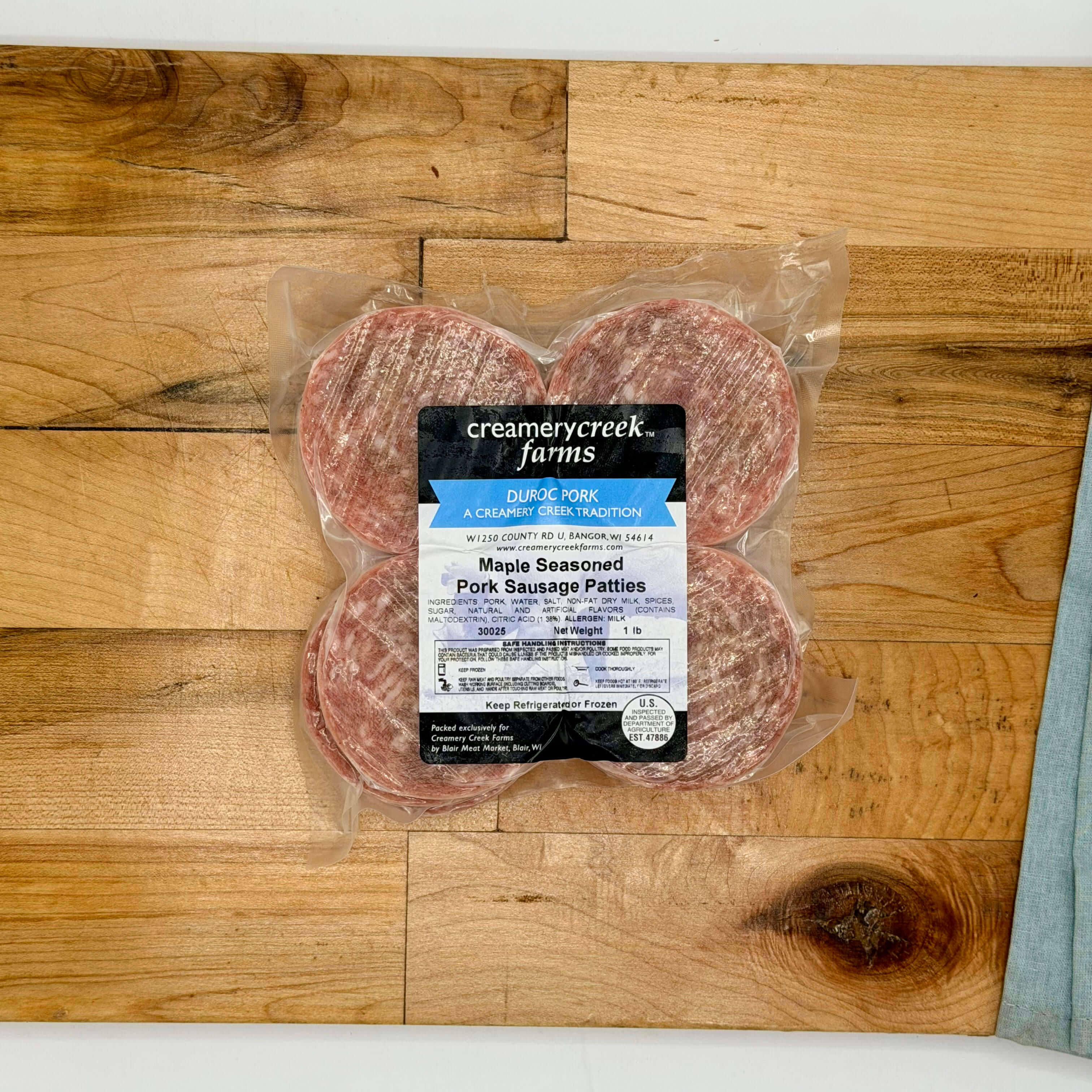 Packaged Maple Seasoned Pork Sausage Patties from Creamerycreek Farms on a wooden surface