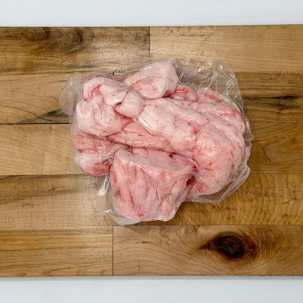 Packaged raw pig fat on a wooden cutting board