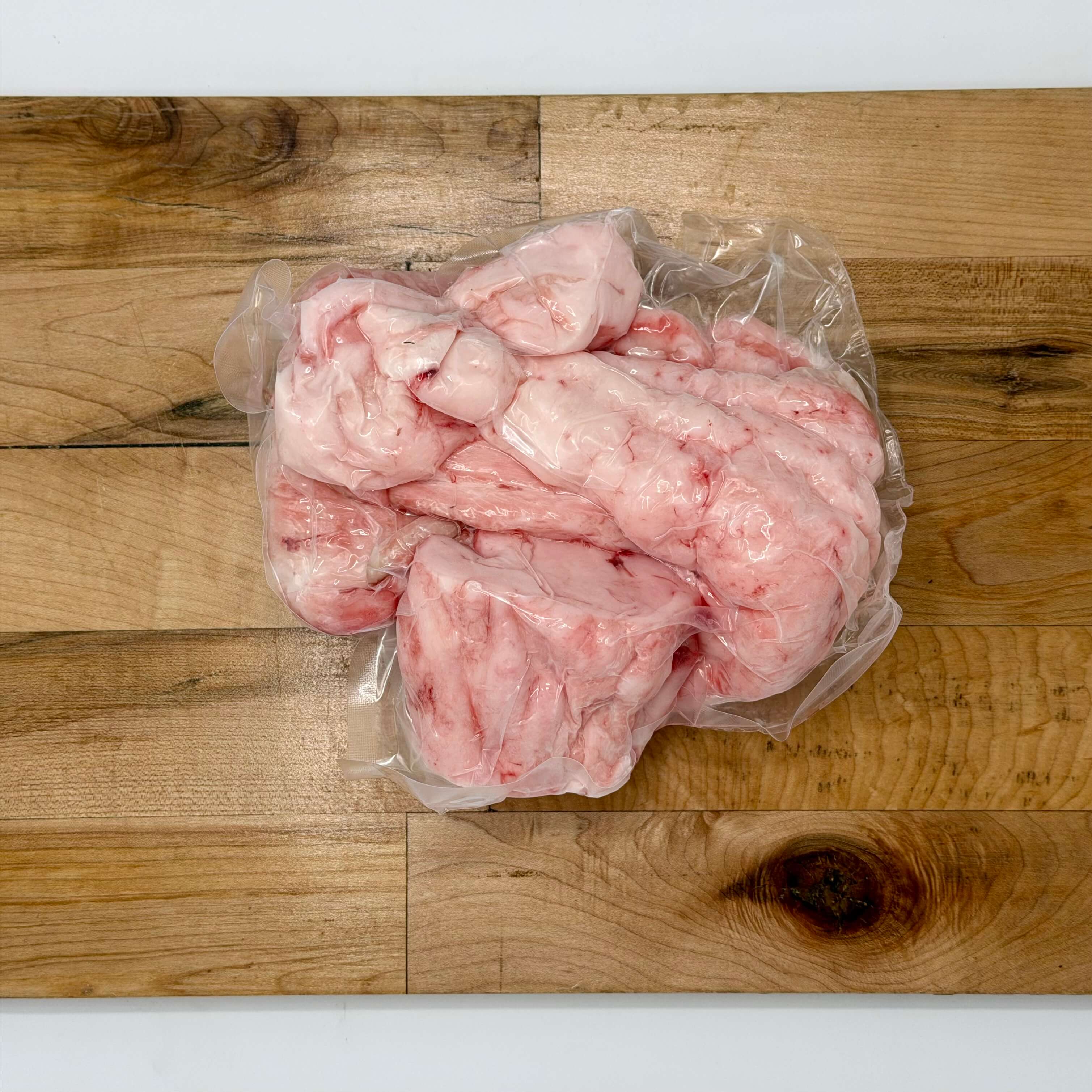 Packaged raw pig fat on a wooden cutting board