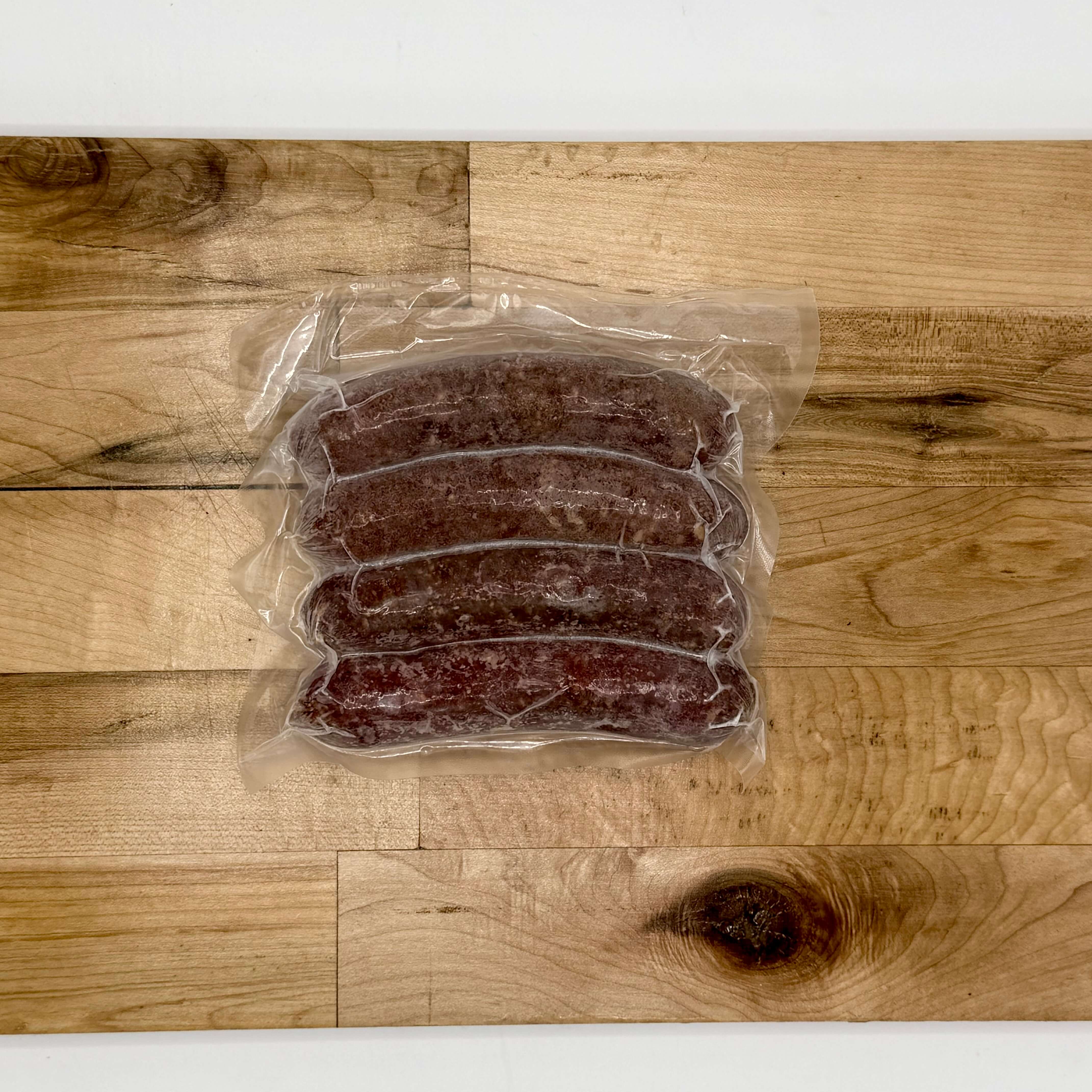 Packaged sausages on a wooden surface