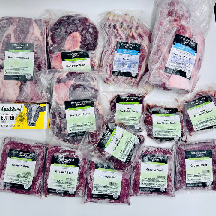 A collection of packaged meat products including beef bones, beef soup bones, beef top round mash, ground beef, and a package of butter.