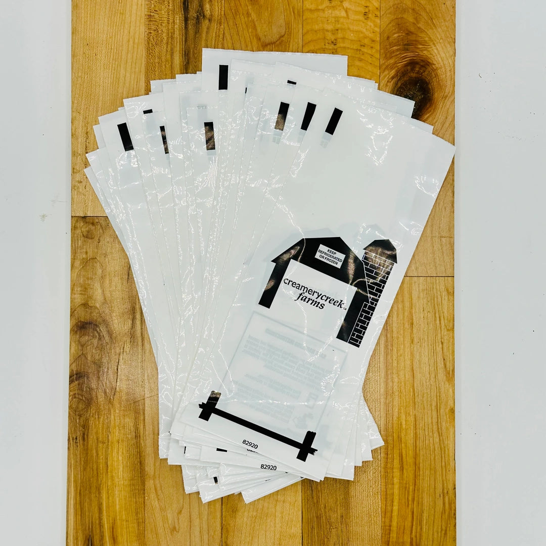 Stack of clear plastic bags with printed designs on a wooden surface