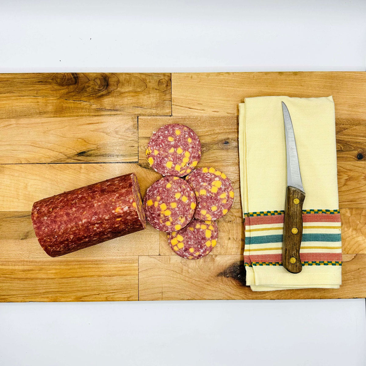 All Beef Summer Sausage next to a knife on a napkin