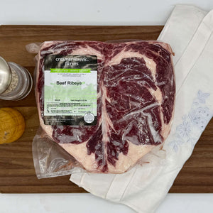 Beef ribeye on a cutting board with a label from Creamer Creek Farms.