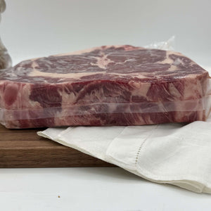 Packaged raw meat on a wooden cutting board with a white napkin