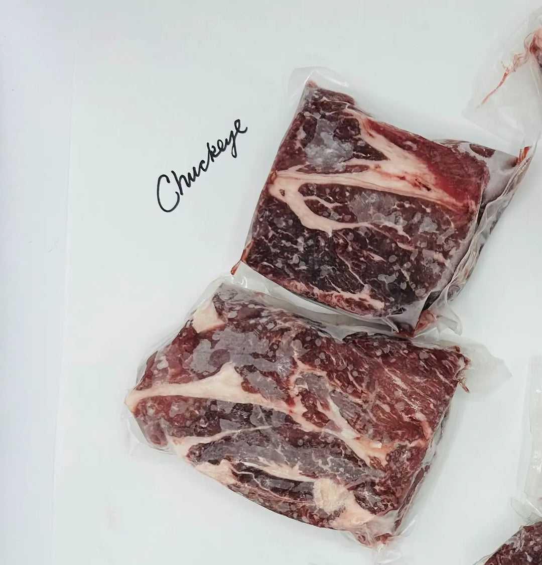 Two pieces of raw beef on a white background with &